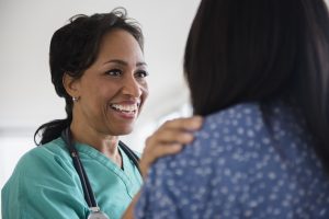 Smiling nurse comforting patient